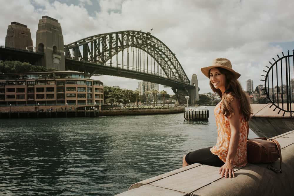 Kvindelig turist i Sydney, Australien som nyder udsigten til Harbour Bridge.